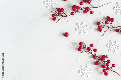 Fototapeta Kompozycja świąteczna lub zimowa. Płatki śniegu i czerwone jagody na szarym tle. Boże Narodzenie, zima, koncepcja nowego roku. Płaski układanie, widok z góry, kopia przestrzeń