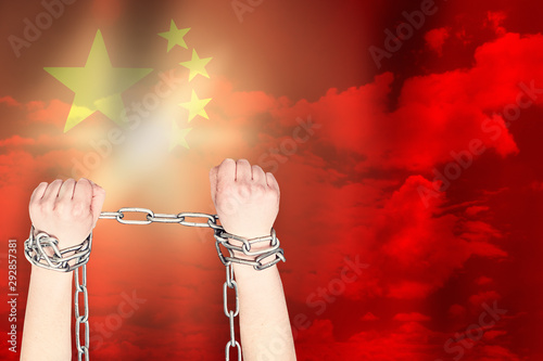Two hands shackled a metal chain on the background of the China  flag. Freedom concept photo
