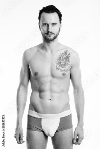 Studio shot of young shirtless man standing and wearing underwear