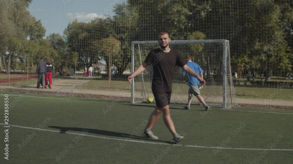 Soccer striker taking a penalty kick and scoring a goal during football match. Joyful teammates congratulating football player and celebrating together scoring after successful penalty shot on field. Soccer striker taking a penalty kick and scoring a goal during football match. Joyful teammates congratulating football player and celebrating together scoring after successful penalty shot on field.