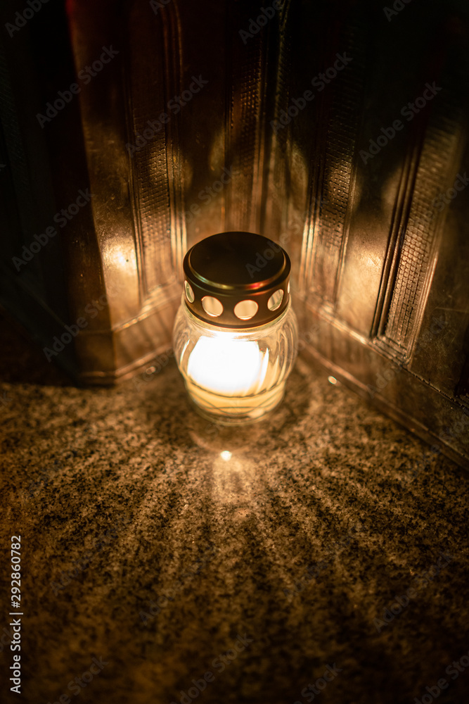 Jars with burning candles on stone surface at night