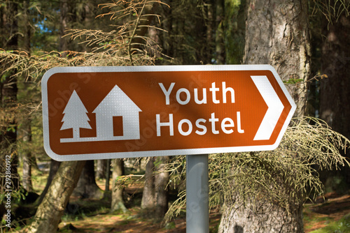 Youth Hostel sign in UK, with blurred forest background taken on sunny day at Rowardennan on West Highland Way photo