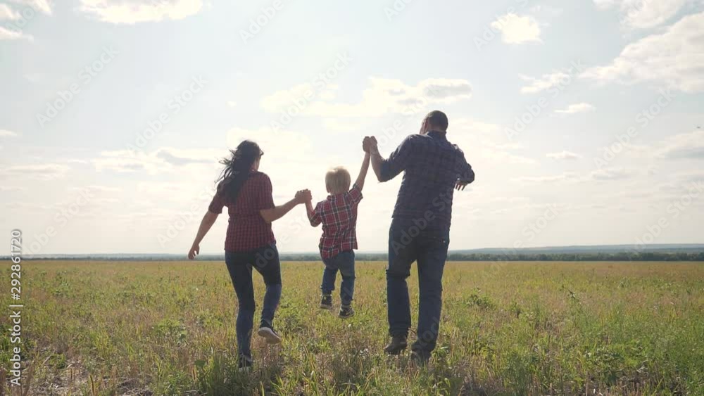 happy family runs nature teamwork friendship care concept slow motion video. father mom and son running in nature sunset sunlight hold hand. happy family parents man and lifestyle girl hold little boy