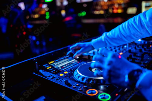 control DJ for mixing music with blurred people dancing at party in nightclub © Семен Саливанчук