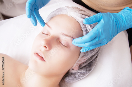Closeup of young woman receiving face massage from massage therapist.