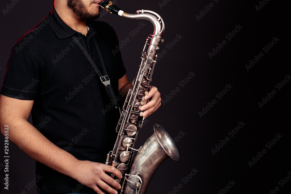 Obraz premium young guy plays the saxophone. Close up