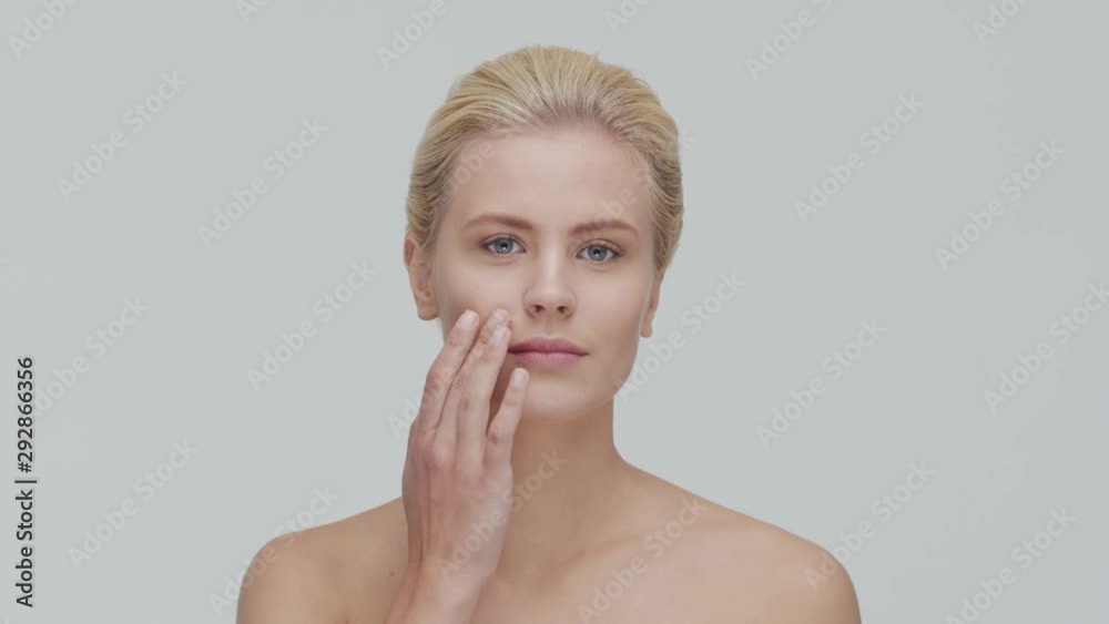 Studio portrait of young, beautiful and natural blond woman applying skin care cream. Face lifting, cosmetics and make-up. Studio portrait of young, beautiful and natural blond woman applying skin care cream. Face lifting, cosmetics and make-up.