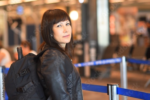 Beautiful tourist woman with backpack in international airport.