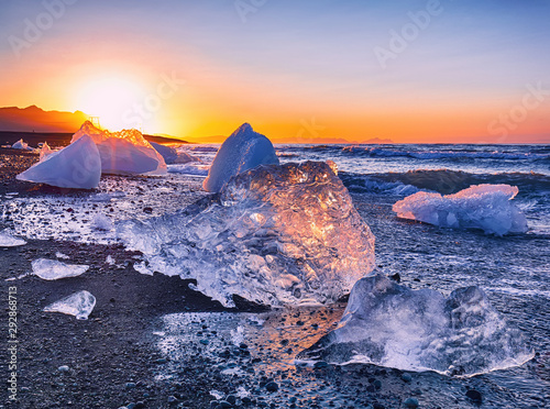 Fotografi Incredible pieces of the iceberg sparkle on famous Diamond Beach at  Jokulsarlon