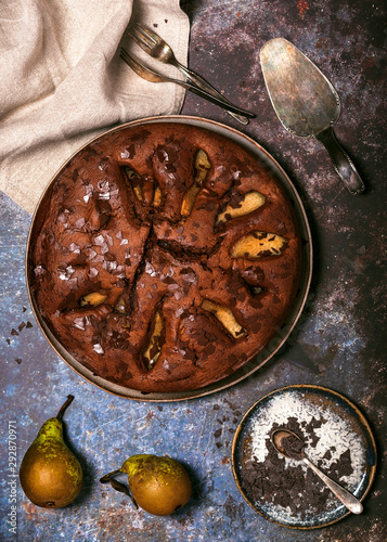 Delicious homemade autumn chokolate fruit pie with some fresh pears on dark rustic background. Top view. photo