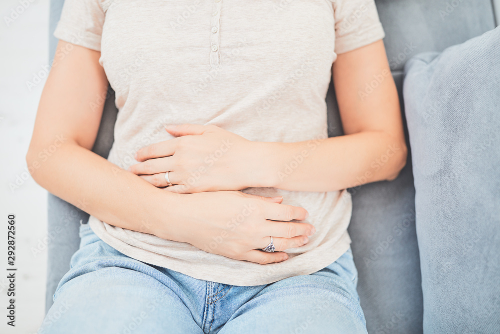 Woman with stomach issues / problems while lying on the couch. Woman with stomach issues / problems while lying on the couch.