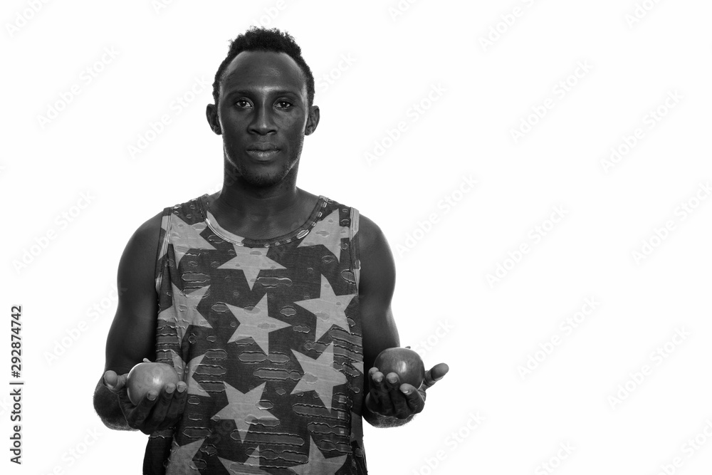 Young black African man holding green and red apple Young black African man holding green and red apple