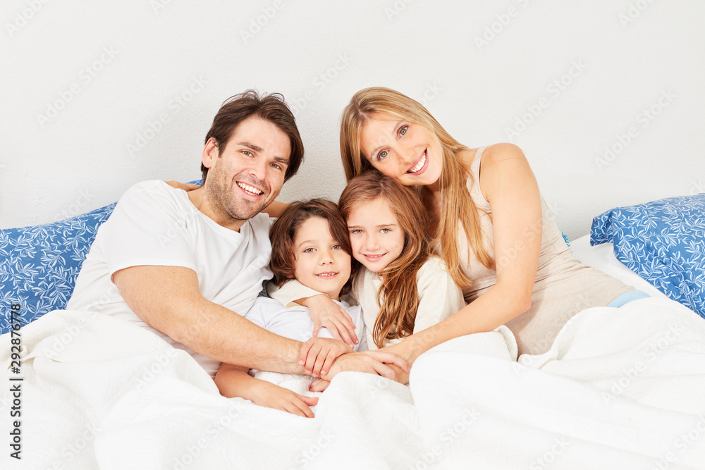 Glückliche Eltern und zwei Kinder beim Kuscheln