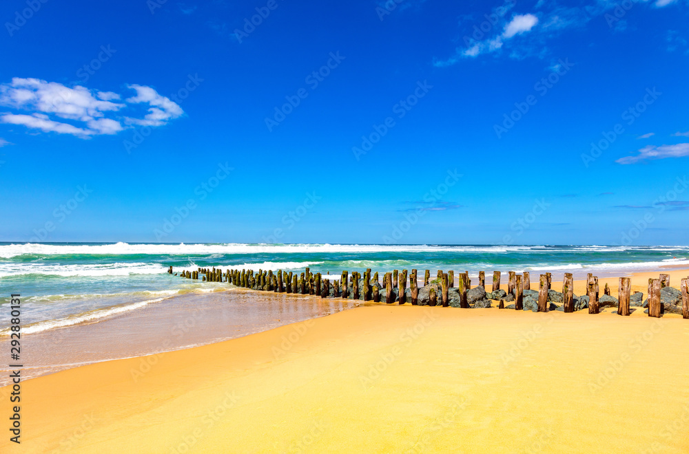View of wooden pillars and stones on the beach of Seignosse, Landes, France