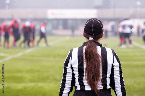 Foto rear view of female american football referee