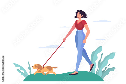 Young woman walking a dog in the park. Attractive girl