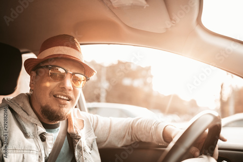 Casual man drive taxi electric car. Transportation. Car driver in sunglasses on the road in summer sunset. Trip © Yevhen