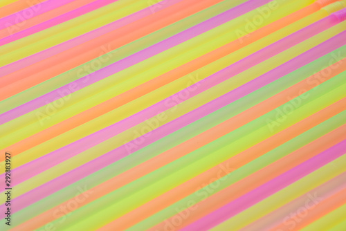 The abstract background of multi-colored tubes for a cocktail is located on an oblique line. Bright saturated colors.