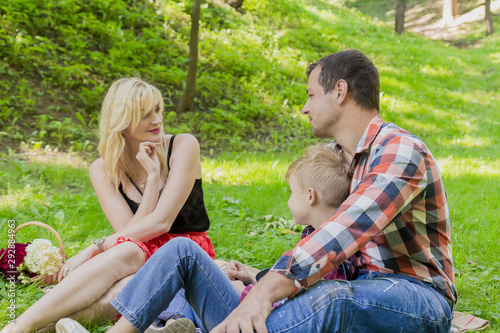 Beautiful happy family resting on a picnic on a sunny day.