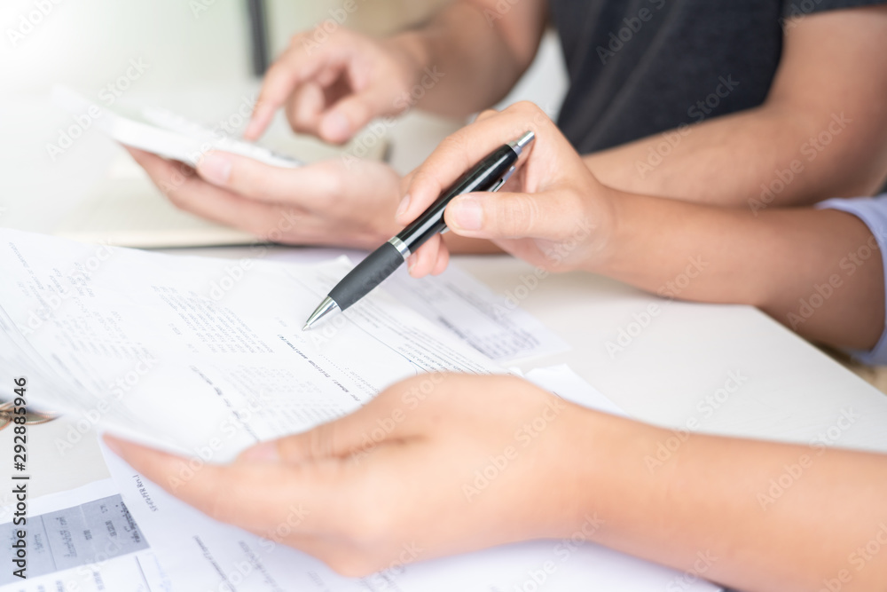 Fototapeta premium couple working saving account book and calculating her monthly expenses on calculator to calculate financial data, filling in individual income tax return.