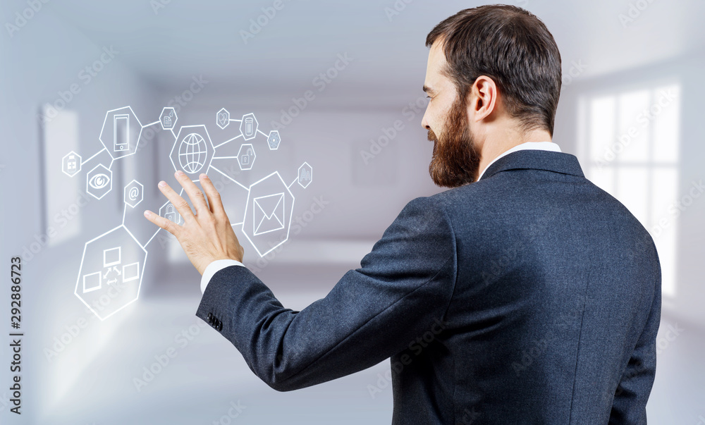 Businessman controls virtual glowing icons by hand. Businessman controls virtual glowing icons by hand.