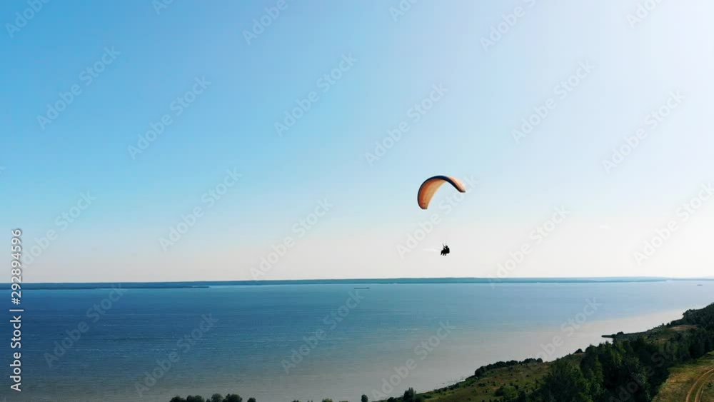 People flying with a paraglider and wave hands. People flying with a paraglider and wave hands.
