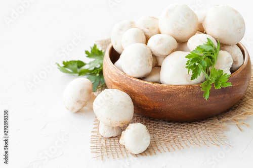 Fotografie, Obraz Fresh mushrooms champignon in brown bowl on white background.