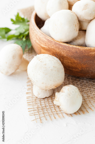 Fresh mushrooms champignon in brown bowl on white background. 