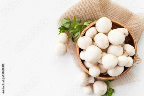 Fresh mushrooms champignon in brown bowl on white background. 