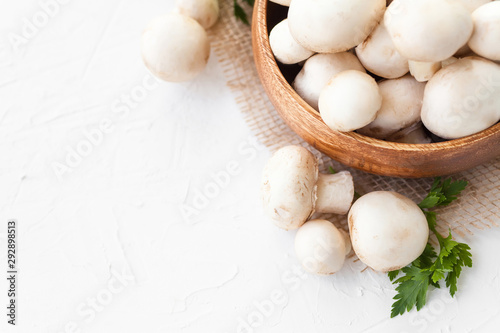 Fresh mushrooms champignon in brown bowl on white background. 