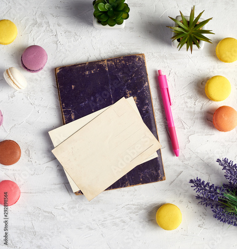 baked round macarons, empty postcards, notebook, pink pen