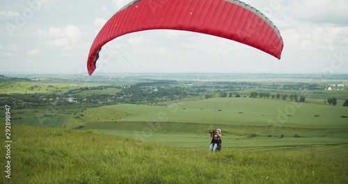 Sportsperson starting paragliding activity in countryside area, active recreation activity