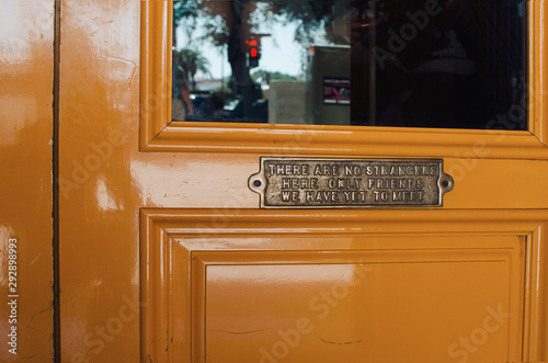 Yellow wooden door of an irish pub in Seville with a banner 