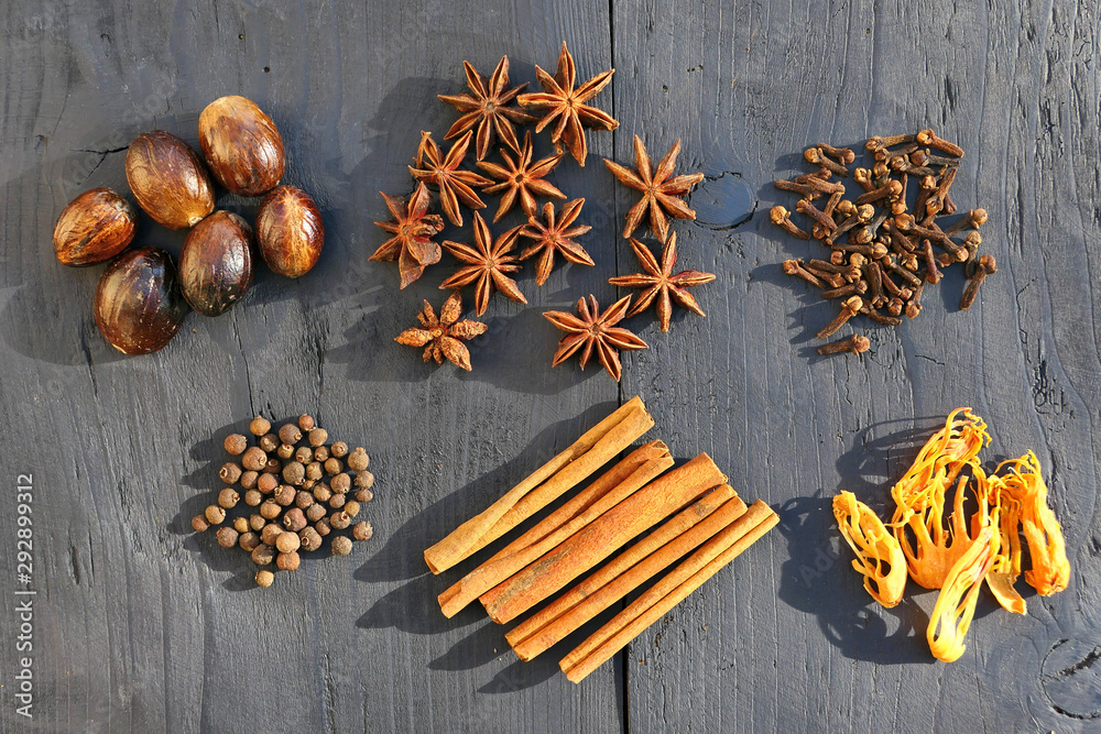 Collection of warming brown spices on wooden background
