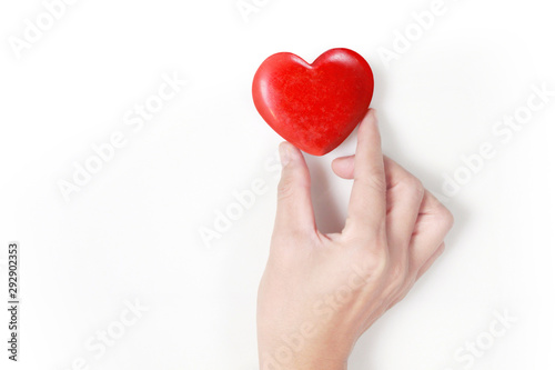 Hands holding red heart, heart health, and donation concepts...