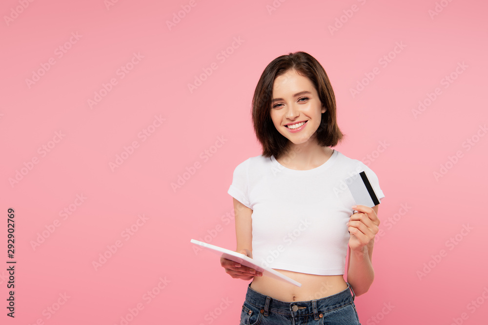 smiling girl holding digital tablet and credit card isolated on pink smiling girl holding digital tablet and credit card isolated on pink