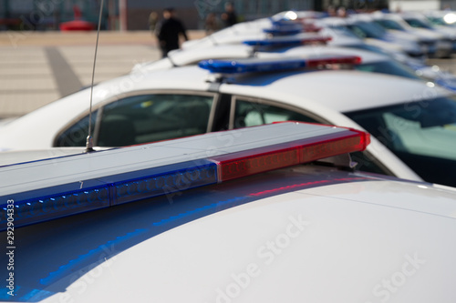 Police lights. Blue and red sirens on the roof of police car while policemen patrol the city