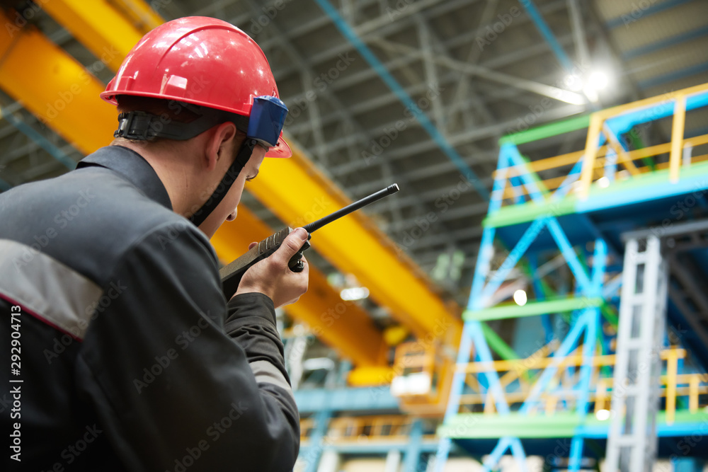 industrial worker on factory with walkie talkie transmitter