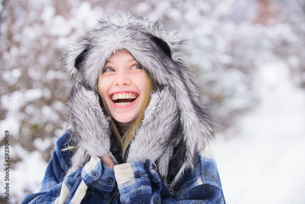 Wintertime. Close up portrait of smiling girl in snow park. Beautiful young woman in winter. Winter holidays. Beautiful girl in warm coat and fur hat. Snowy park. Wintertime. Close up portrait of smiling girl in snow park. Beautiful young woman in winter. Winter holidays. Beautiful girl in warm coat and fur hat. Snowy park.