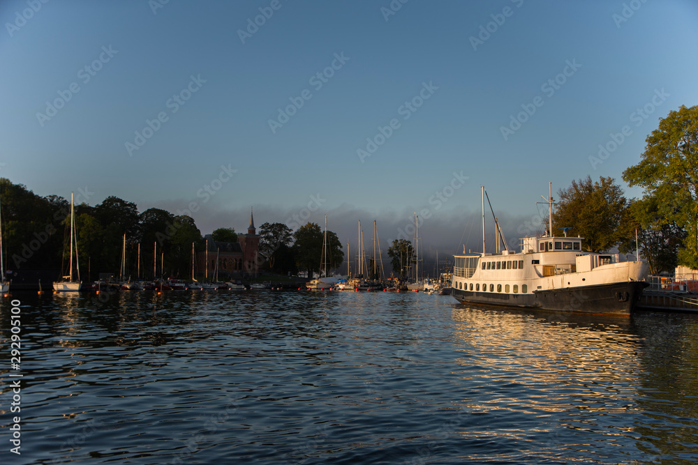 Naklejka premium Morning view over Stockholm inner harbour with boats, canoes, piers and islands an autumn day