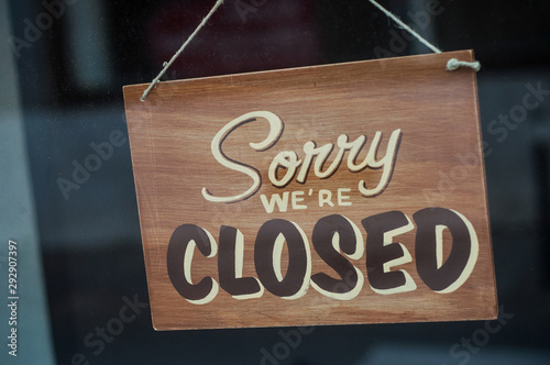 Closeup of wooden panel on store front : Sorry we are closed photo