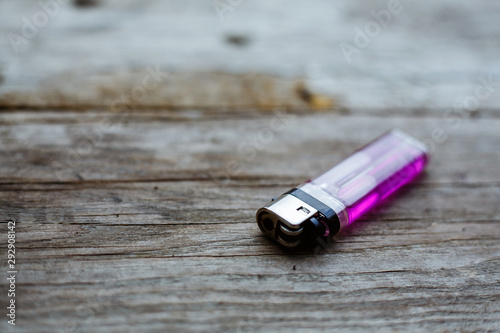 Close up of a pink lighter on a wooden background. photo