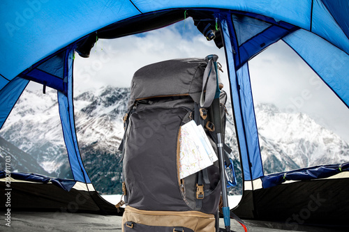 Winter backpack in blue tent and mountains landscape 