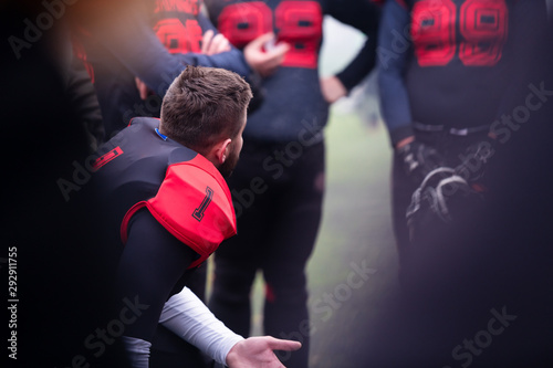 american football player discussing strategy with his team