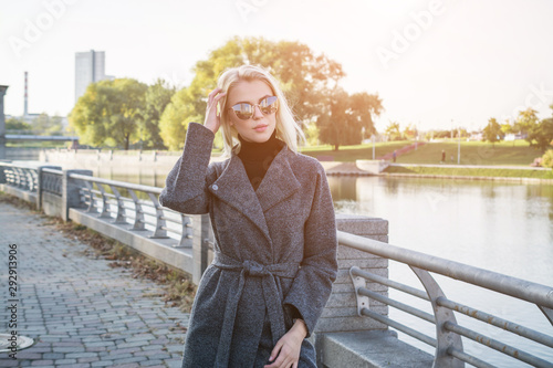 beautiful stylish girl with white hair in an autumn coat, photographed in a city park © bisonov