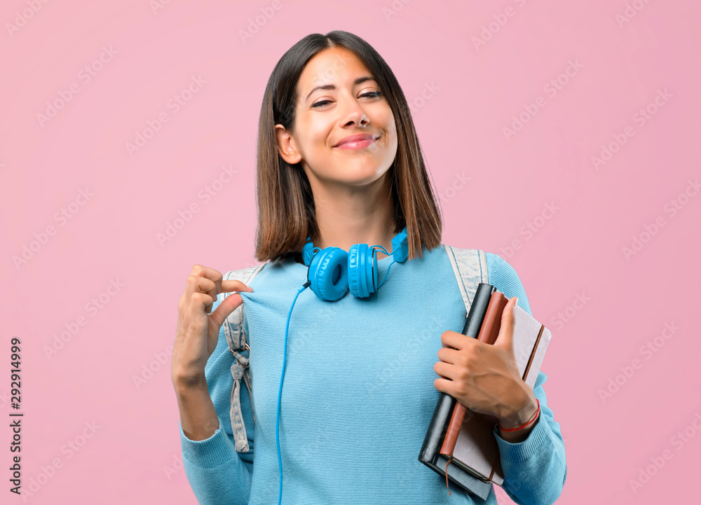 Young student girl with blue sweater and headphones proud and self-satisfied in love yourself concept on pink background Young student girl with blue sweater and headphones proud and self-satisfied in love yourself concept on pink background