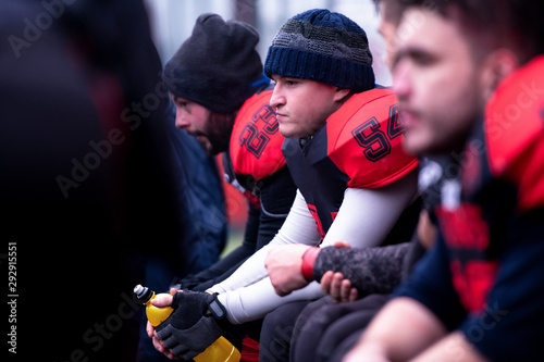 Картината върху платно american football player resting with teammates