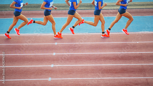Female athlete runs on the athletic track. Running movement phases concept.