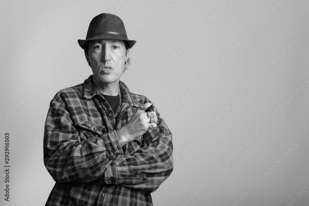 Studio shot of mature gangster man holding cigar Studio shot of mature gangster man holding cigar