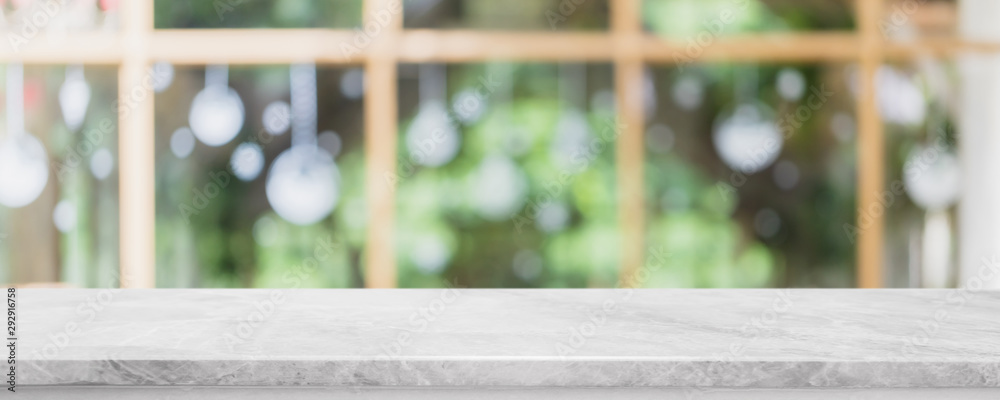 Empty white stone marble table top and blurred of interior restautant with window view green from tree garden background banner background - can used for display or montage your products.